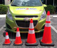 Image of four orange traffic cones of varying height in the foreground. All have a confidence score of 0.90 or above