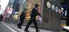 New York police officers investigate an early-morning explosion outside the U.S. Armed Forces Career Center, which sits on a traffic island in Times Square, Thursday. The explosion caused minor damage to the building and temporarily shut down the area.