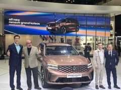 Officials from Renault Korea Motors pose for photos next to the company's newly unveiled Grand Koleos hybrid SUV at the Busan International Motor Show on June 27, 2024. (Yonhap)