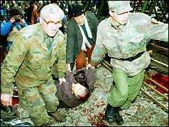 Photo of an injured man being helped by soldiers