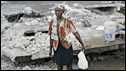 A woman stands in front of her destroyed house in Leogane. Photo: 11 February 2010