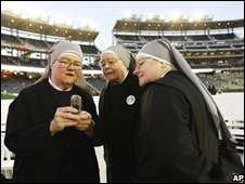 Nuns look at a mobile phone before the Pope led Mass for 48,000 in a Washington stadium
