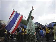 A protester waves a Thai flag in the compound of Government House in Bangkok