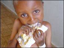 A child eats from a sachet.
