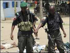 A Nigerian police officer points at a corpse in the northern city of Maiduguri on Wednesday