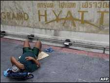 A protester sleeps in front of the Grand Hyatt hotel in Bangkok, 12/05