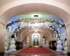 The East Colonnade is decorated with crystals hanging in the air like snowflakes, ribbons cascading from the ceiling, and rows of trees twinkling brilliantly just outside the windows.
