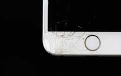 A close-up of a broken white iPhone.