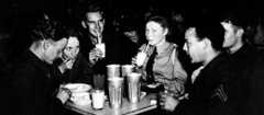 A group of people enjoy milkshakes or malted milk, soft drinks and ice cream sundaes