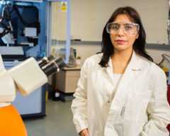 A Pharmacy postgraduate student posing next to medical equipment.