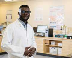 A Biomedical Science student wearing a lab coat posing in a lab.