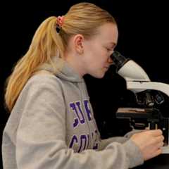 Curry student views a specimen through a microscope