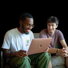 Student work on a laptop together on a couch