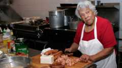 Leah Chase cutting sausage