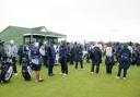 Players and caddies gather on the course, awaiting further instructions after play is suspended during day three of the 2025 Alfred Dunhill Links Championship
