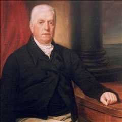 Head and shoulders portrait of a white man with white hair, and a black jacket. A red curtain and pillar are behind him, and he rests his hand on a ledge. 