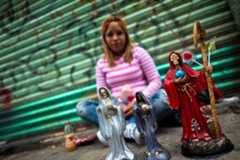 Santa Muerte usually appears as a skeletal figure covered most often in a white, black or red robe and carrying a scythe and a globe.