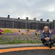 Amy Callaghan, Pigs in Mud Arts Studios, in front of her mural.