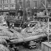 Shoppers stop to watch the mammoth building works to culvert the Blakewater many feet beneath Salford Blackburn in 1963.