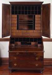 Desk with large drawers and cabinet doors open and showing smaller drawers and cubbies.
