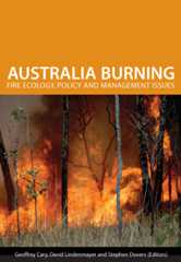 The cover image of Australia Burning, featuring a raging fire, with trees on fire and long dry grass in the foreground.