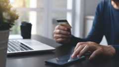 Image of figure using their phone and credit card for banking services