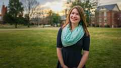 Savannah Scott '17 portrait shot on the back quad in a black dress with a green scarf.