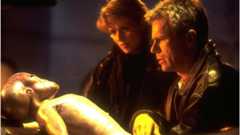 Amanda Tapping and Richard Dean Anderson looking at an alien body in Stargate SG-1