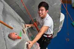 student climbing on the rock wall in the HLES center