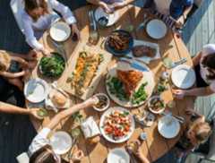 people eating on table with foods