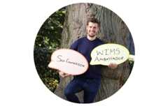 This image shows ultrarunner Conor O'Keeffe holding a sign saying Walk in My Shoes Ambassador.