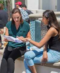 Faculty mentoring student outside in union.