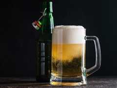 Bottle and pint of beer on a black background