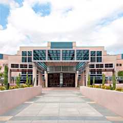 Mayo Clinic building with cactus-lined walkway and clear blue sky in Scottsdale, Arizona.