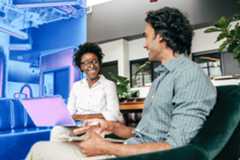 Two people on a security team sit at laptops together.