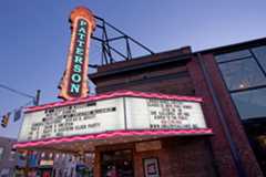 The marquee at Creative Alliance glows under a dusky sky