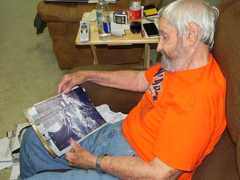 Donald Cook shows photos taken while serving in Korea. Pictured here is Cook with quarry taken during a hunting trip.