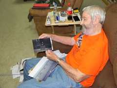 Donald Cook shows a photo of himself in front of the quad tents where he lived while serving in Korea.