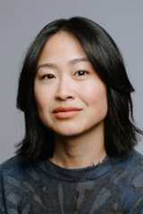 A woman smiling softly into a camera.