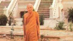 a person in orange robe standing outside of stairs