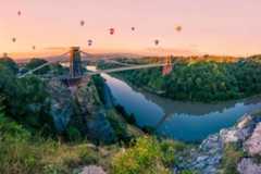 Hot air balloons and bridge over river bend