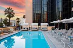 Pool at sunset with lounge chairs and daybeds.