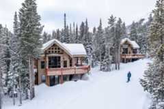Mountain cabin surrounded by trees in the snow