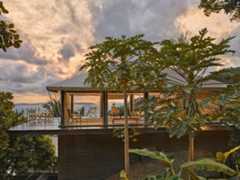 Tourist enjoying sea view at sunrise from villa.