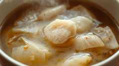 A gentle photo of a thick, clear broth (ankake style) with sliced turnip (kabu) and chicken pieces, highlighting the comforting texture.