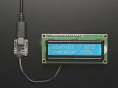 Overhead video demo of an LCD backpack wired to a small square microcontroller. Display on LCD reads: "adafruit (heart symbol) 16x2 character LCDs"