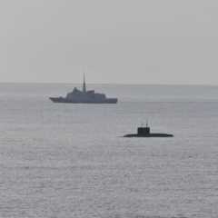 A French Navy vessel watches the surfaced Russian sub Novorossiysk this week.