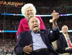 Former U.S. President George H.W. Bush participates in the coin toss ahead of the start of Super Bowl LI between the New England Patriots and the Atlanta Falcons as former first lady Barbara Bush looks on in Houston, Texas on Feb. 5, 2017.