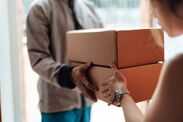 Brits issued major warning as mystery package scams soar - what you need to know Closeup of delivery person handing in a package to customer
