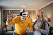 Senior man experiencing virtual reality headset with wife